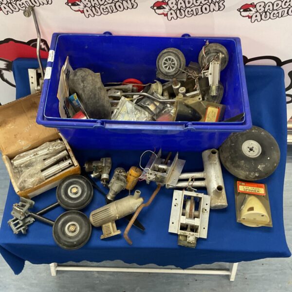 Vintage model aircraft parts lot with propellers and wheels.
