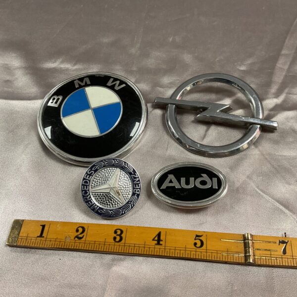 Vintage German car badges including BMW, Audi, Mercedes, and Opel.