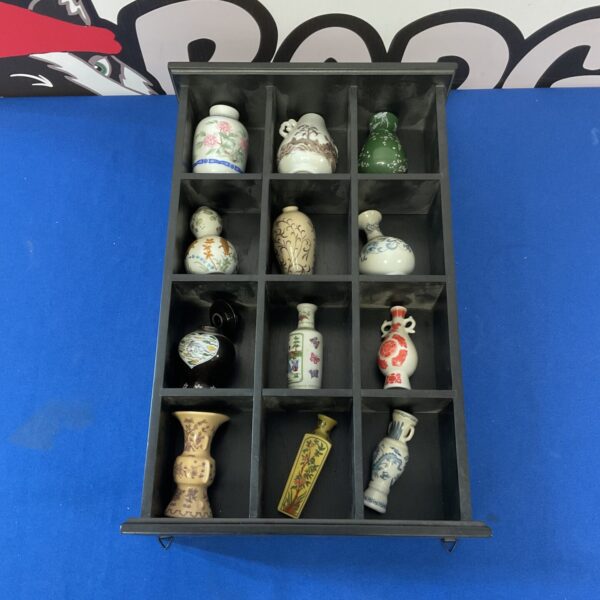 Collection of miniature Japanese porcelain vases on display.