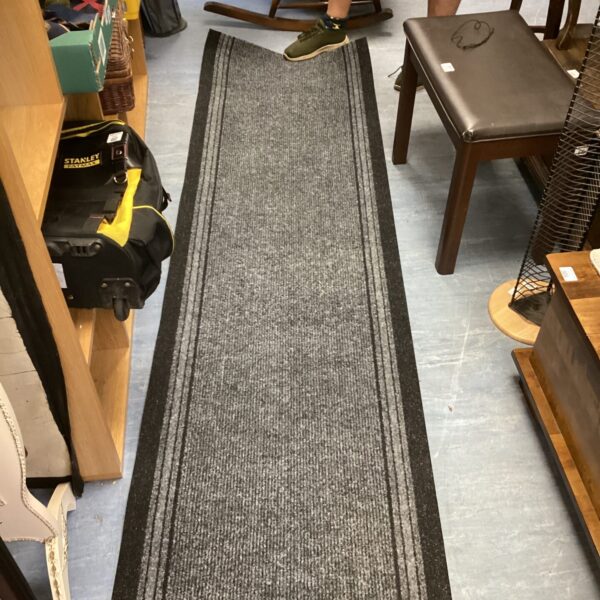 Grey runner rug in a hallway setting, providing floor coverage.