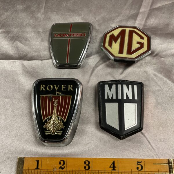 Vintage car badges set including Rover, MG, Mini, and Montego emblems.