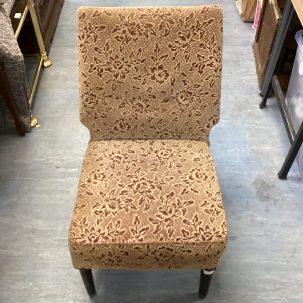 Vintage floral chair with patterned upholstery and dark legs.