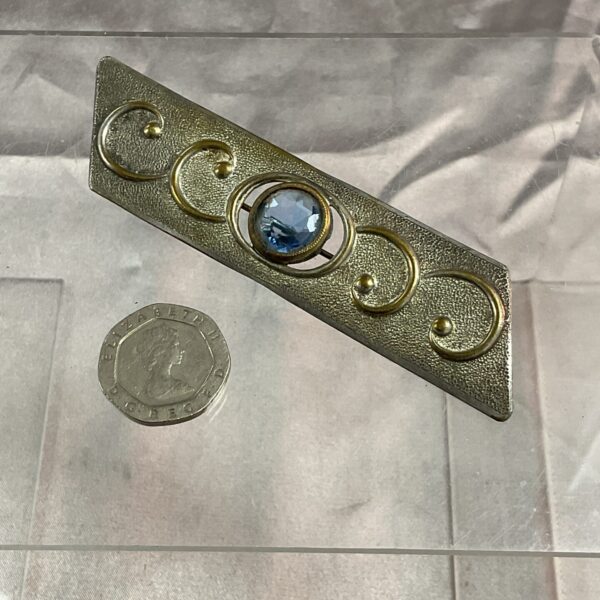 Silver tone Art Deco brooch with geometric design.