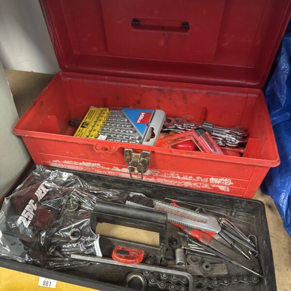 Red plastic toolbox filled with a variety of hand tools.