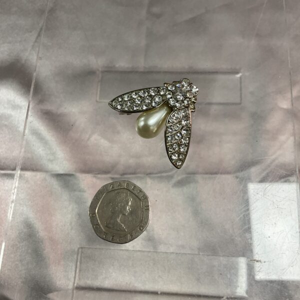 Sparkling vintage bee brooch with rhinestones and pearl detail.