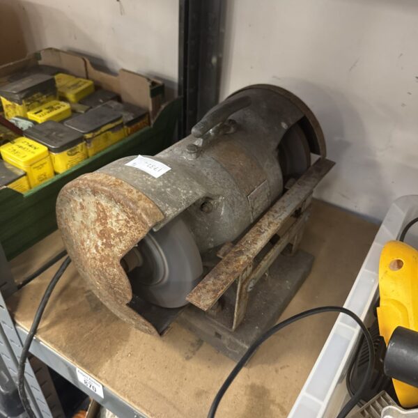 Vintage bench grinder with grinding wheel, workshop tool.