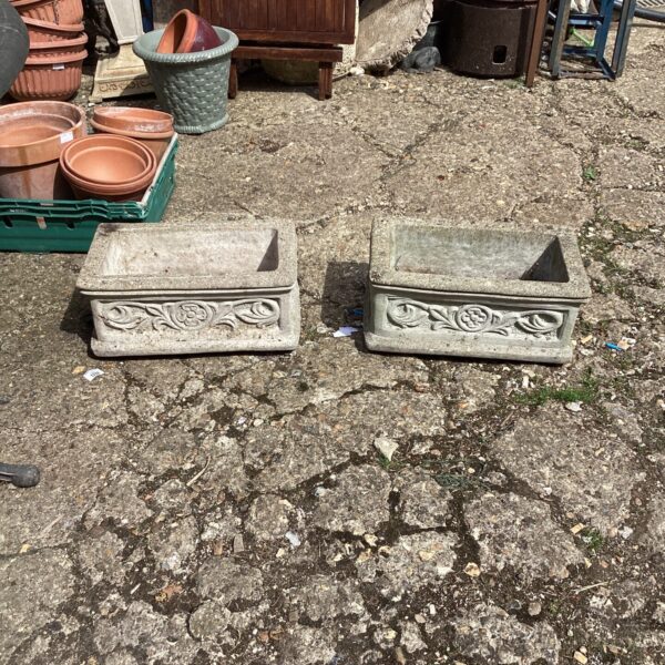 Pair of weathered stone effect garden planters for outdoor display.