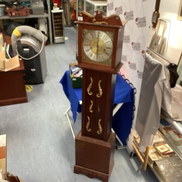 Antique grandmother clock with dark wood finish and Roman numerals.