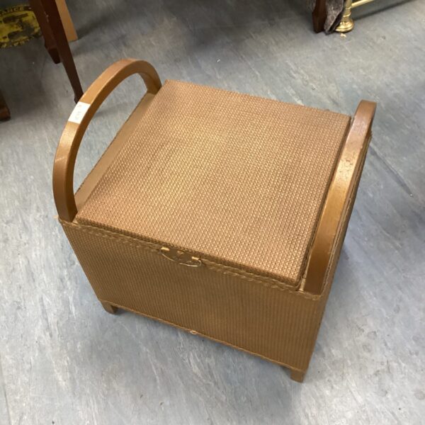 Vintage Lloyd Loom commode with lift-up top for bedroom storage.