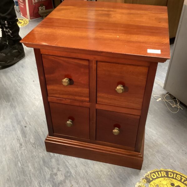 Vintage mahogany four-drawer cabinet for storage and display.