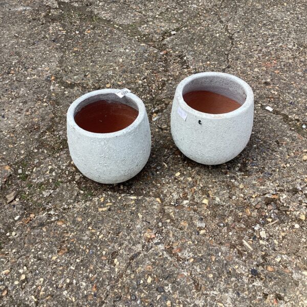 Two weathered terracotta garden plant pots for outdoor use.