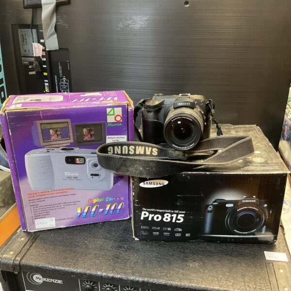 Vintage Samsung pro 815 and Mustek vdc-100 digital cameras on display.