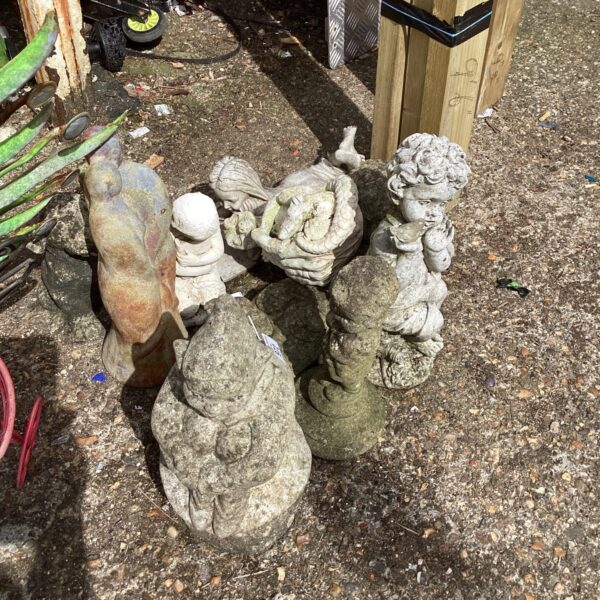 Vintage garden ornaments featuring a cherub statue in a garden setting.