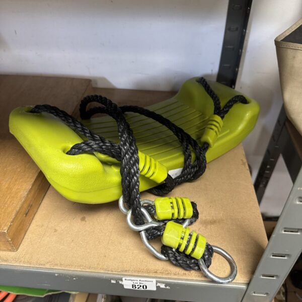 Bright green children’s rope swing for outdoor garden play.