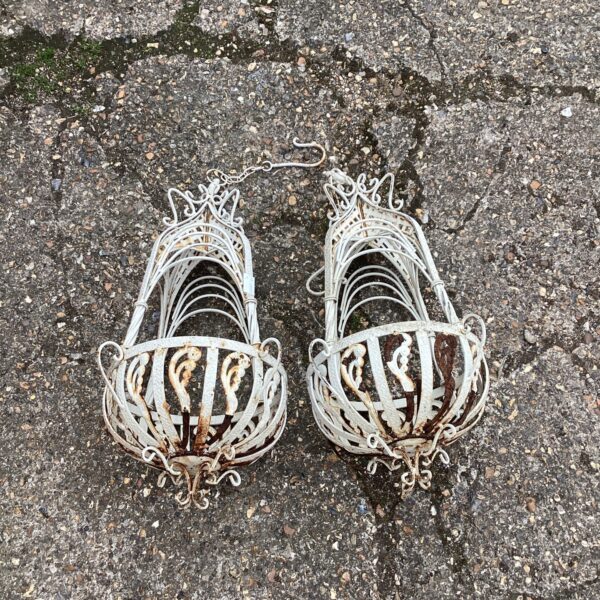 Ornate vintage metal flower baskets for garden display.