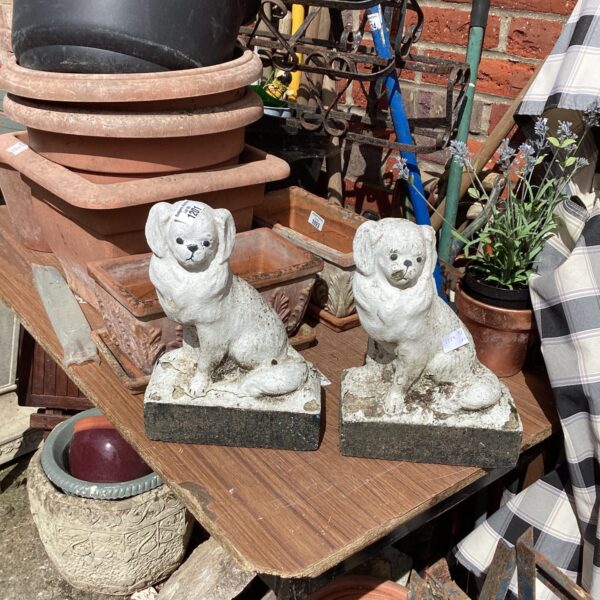 Pair of weathered stone effect garden dog ornaments.