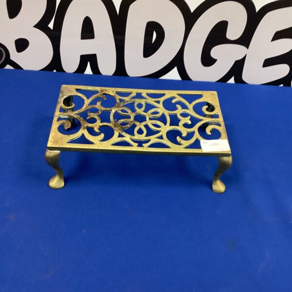Ornate vintage brass trivet with pierced design.