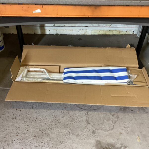 Retracted striped outdoor awning presented as-found.