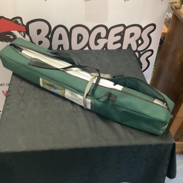 Folded aluminium camping bed ready for outdoor use.