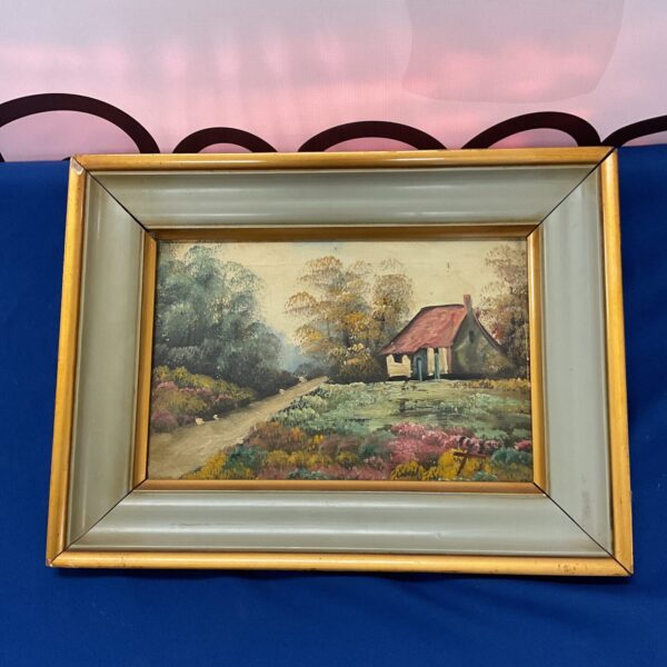 Vintage oil painting of a country cottage with a gilt frame.