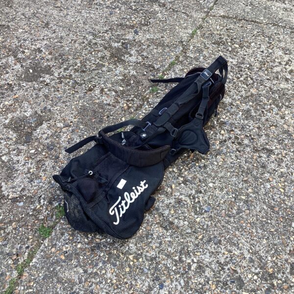 Black Titleist golf carry bag with shoulder strap.