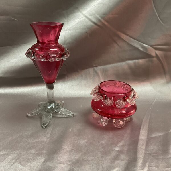 Vibrant Victorian cranberry glass vase and bowl set on display.