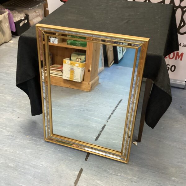 Vintage gold wall mirror with decorative frame.