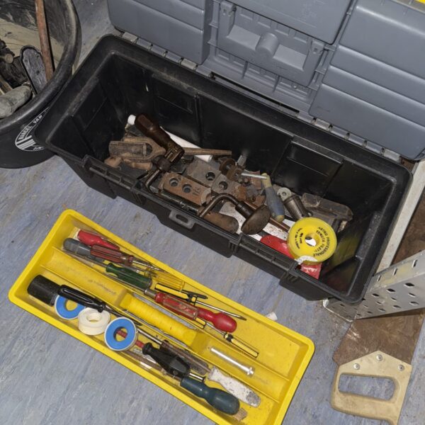 Vintage plastic toolbox filled with metal parts and a screwdriver.