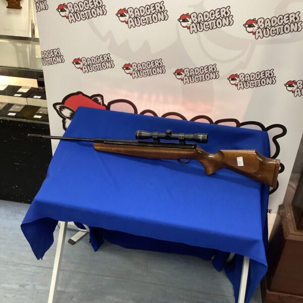 Vintage Webley Tomahawk .22 air rifle with scope, side view.