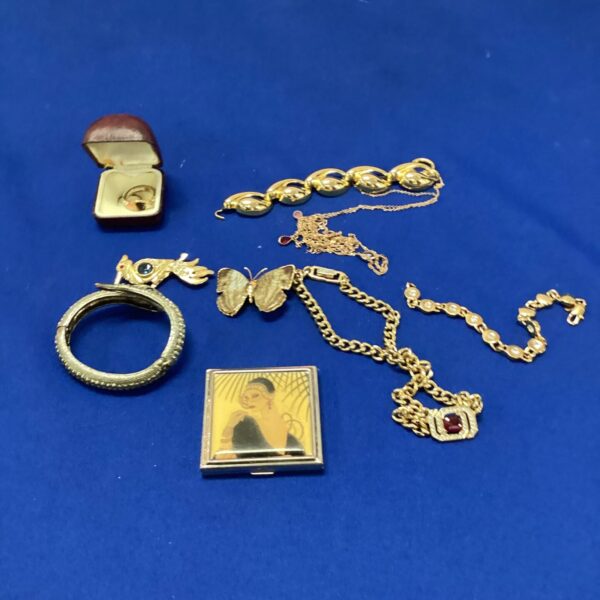 Vintage jewellery lot featuring Art Deco brooches and a vanity mirror.
