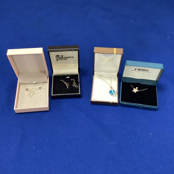 Silver pendant necklaces and earrings set displayed in presentation boxes.