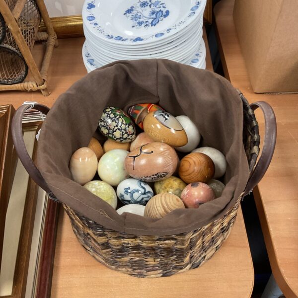 Close-up of a collection of decorative wooden and stone eggs.