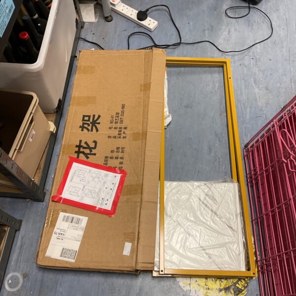Front view of new metal shelving unit in original packaging.