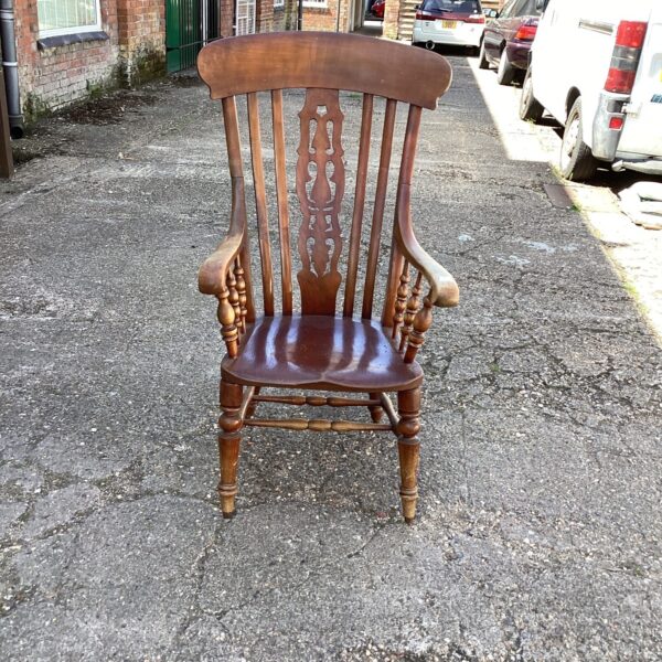 Antique beech and elm Windsor armchair in a garden setting.