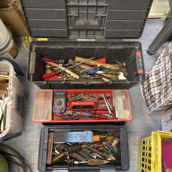 Plastic toolboxes filled with a variety of hand tools and workshop equipment.