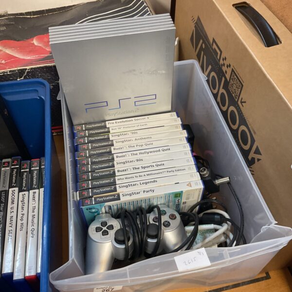 Silver PlayStation 2 console with games for retro gaming.