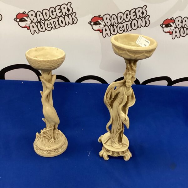 Intricately carved vintage soapstone candle holders on a dark surface.