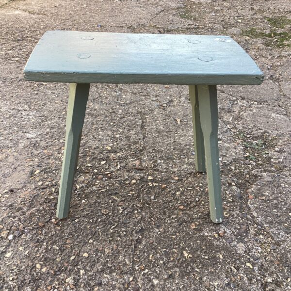 Rustic painted garden stool for outdoor seating and decor.