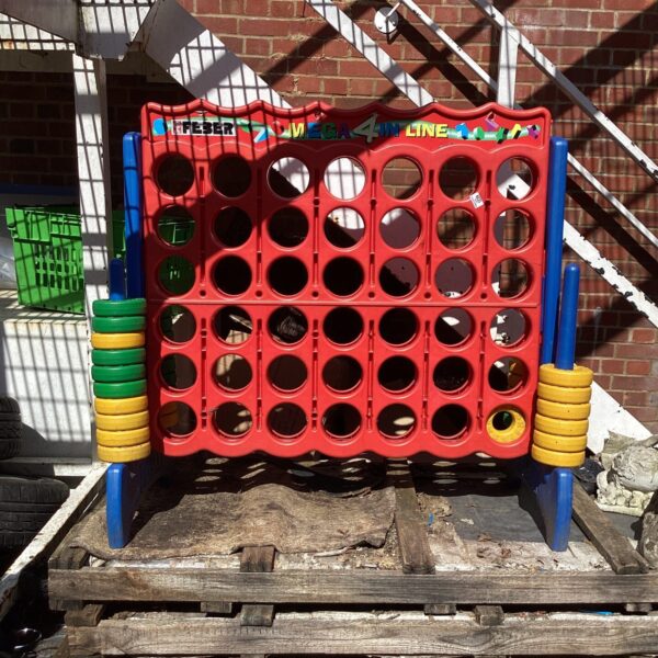 Vibrant red Ferber garden Connect Four game for outdoor play.