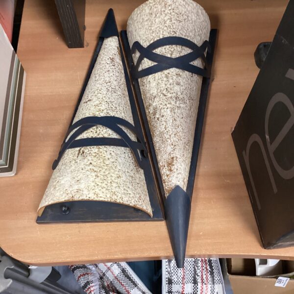Vintage electric wall sconces with textured finish and black metal frame.
