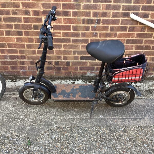 Front view of a used Zipper electric scooter with basket.