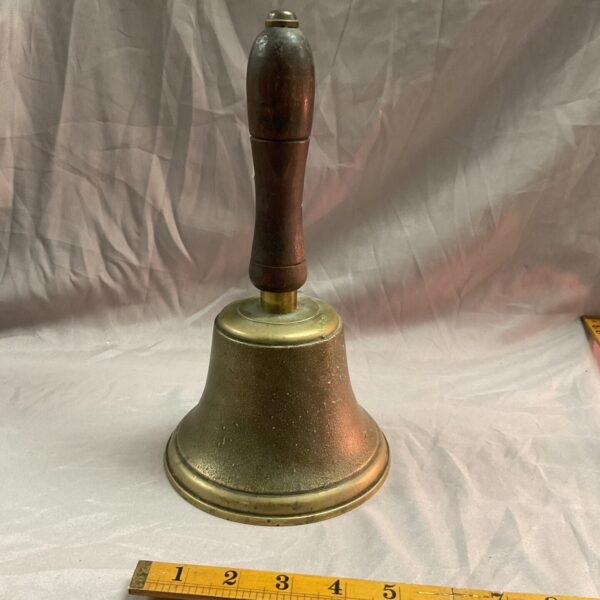 Vintage brass hand bell with wooden handle, antique collectible.