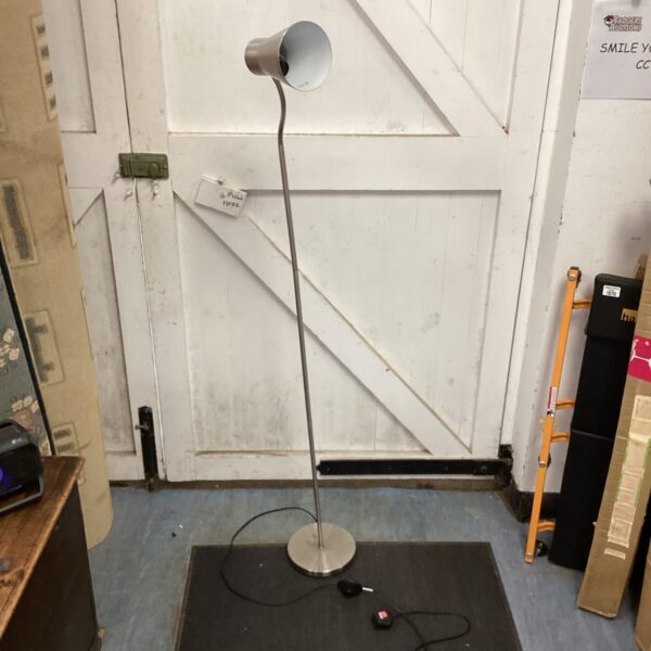 Stainless steel standard lamp with adjustable head and circular base.