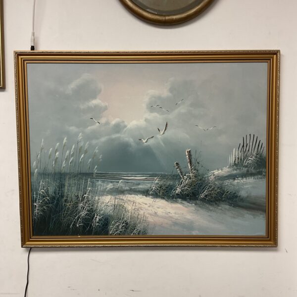 Vintage coastal oil painting featuring seagulls over a beach landscape.