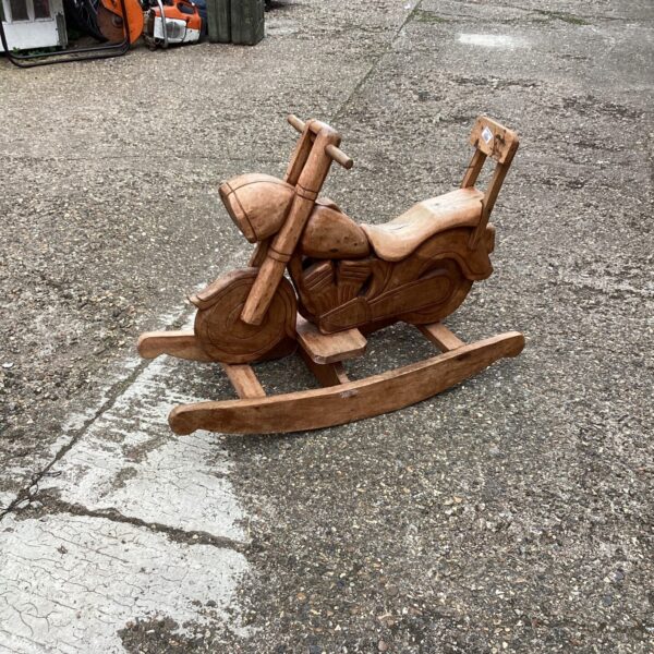Hand-carved wooden rocking motorbike, a vintage folk art toy.