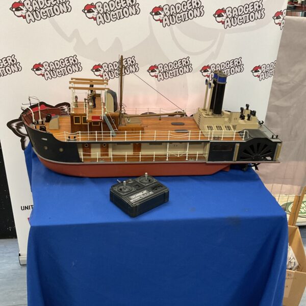 Detailed radio control paddle steamer on a blue table.