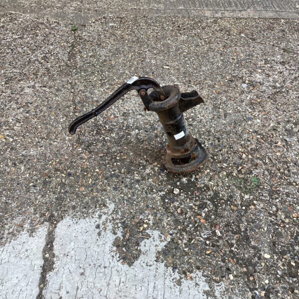 Weathered vintage cast iron water pump head for garden display.