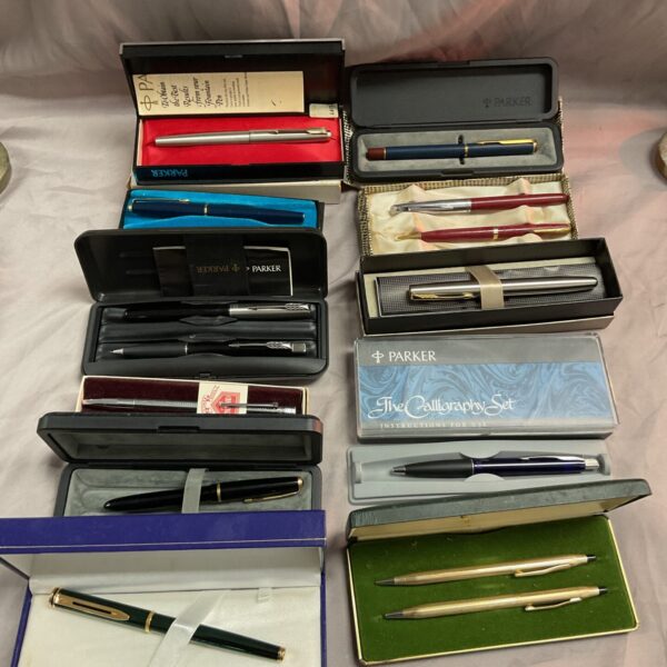 Assorted vintage pens including Parker and Waterman in a box.
