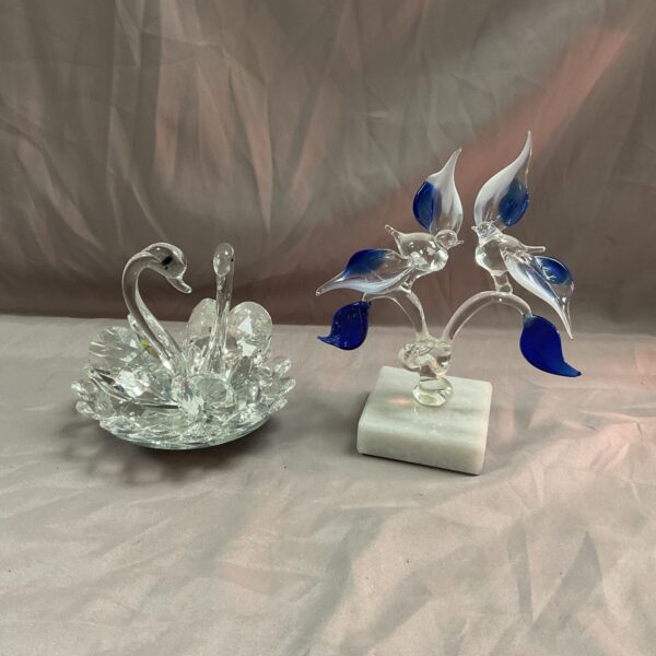 Rotating glass swan sculpture with delicate blue glass birds on marble base.
