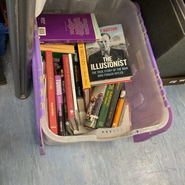 Mixed book lot in a plastic crate, diverse paperback collection.